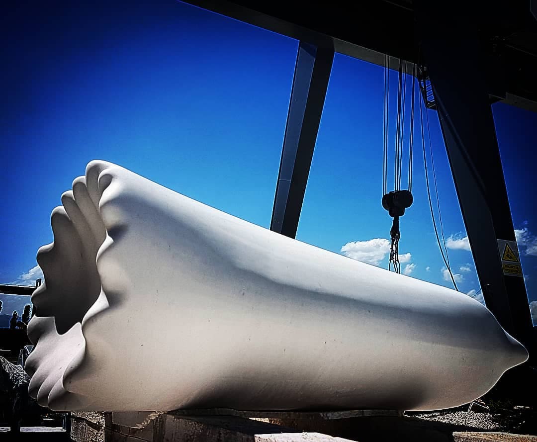 Large white sculptural form in an industrial studio